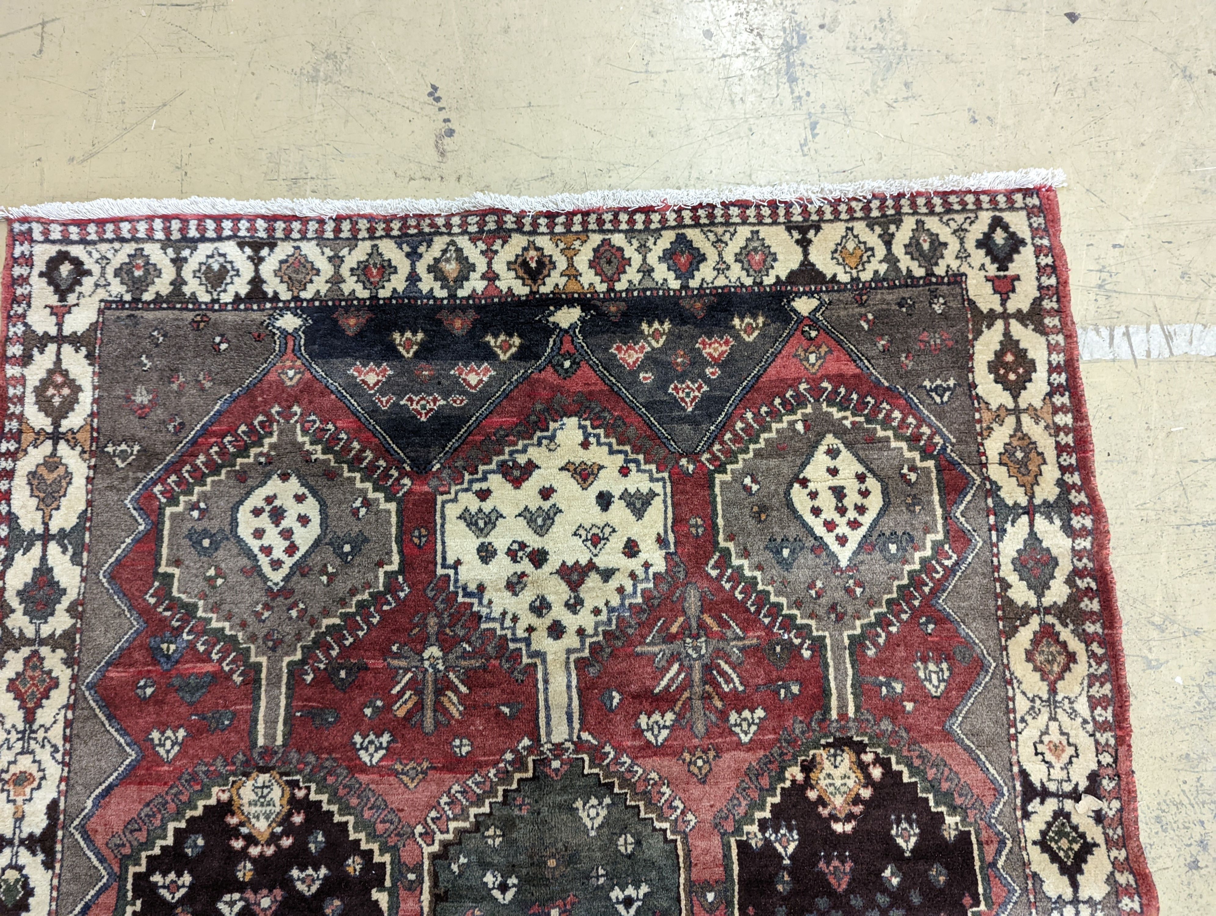 A Persian Shiraz red ground rug, 280 x 150cm